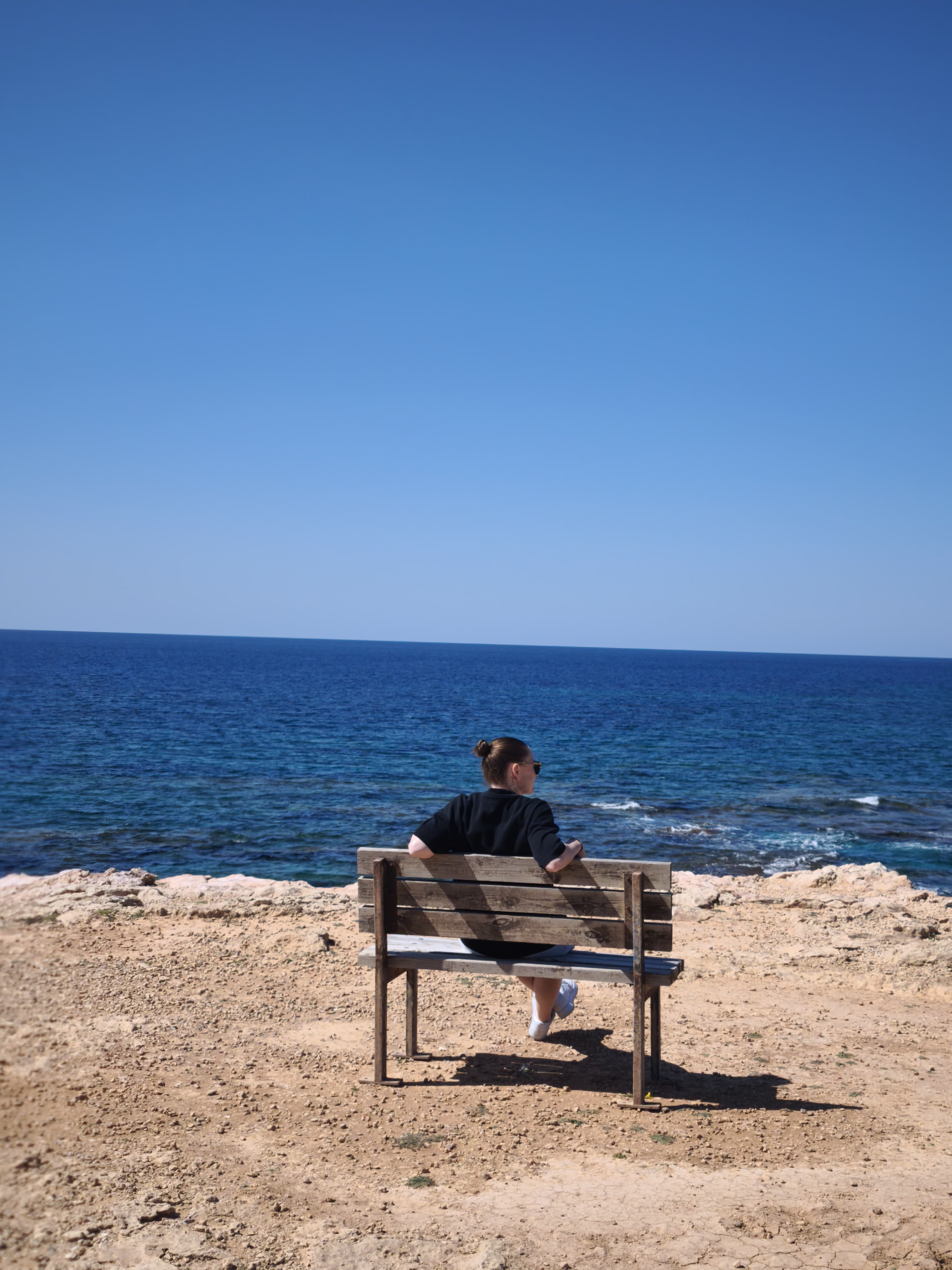 Marie auf einer Bank am Meer